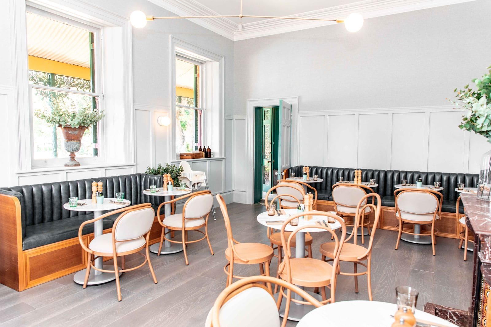 Restaurant with white walls and wooden chairs and tables